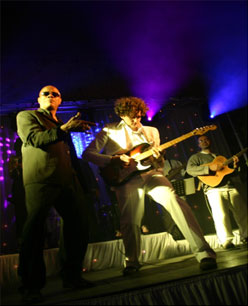Groupe de musiciens sur scène, chanteur et guitaristes sous les projecteurs