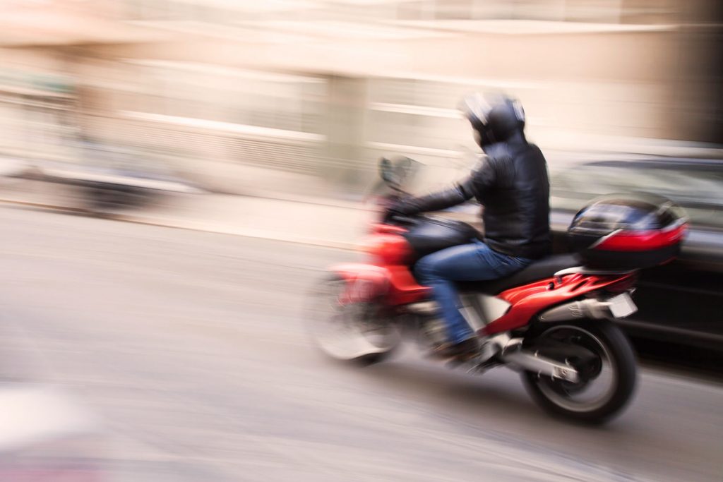 Coursier à scooter transportant les empreintes vers le laboratoire
