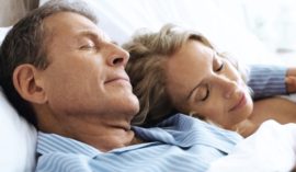 Couple endormi côte à côte dans un lit