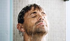 Homme sous la douche, le visage ruisselant d’eau