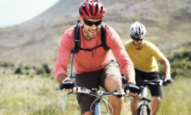 Deux cyclistes casqués roulant sur un chemin de campagne